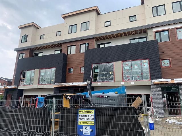 Commercial EIFS storefront facade installation with large panels and active site access