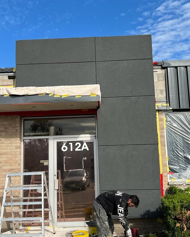 Modern dark acrylic stucco panel facade with clean reveals on a Toronto storefront